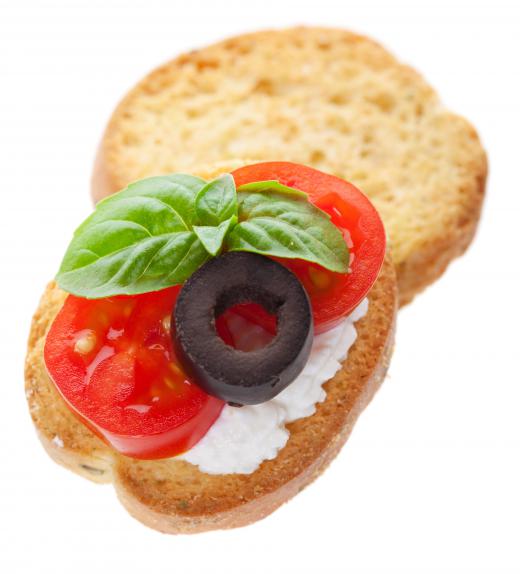 Canapés with cheese, tomato, olive and basil for an Italian-themed party.